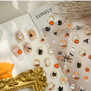 Detail of 3D embossed Halloween nail stickers with gold pumpkin and black cat motifs