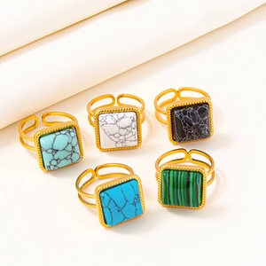 Detailed close-up of five adjustable gold rings with diverse square gemstone textures