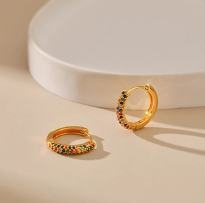 Close-up of 18K gold-plated huggie earrings with rainbow colored cubic zirconia stones