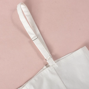 Detalle del tirante ajustable de la camiseta blanca con hebilla de metal plateado