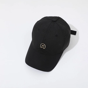 Détail de la casquette noire avec broderie dorée et perforations laser pour la ventilation