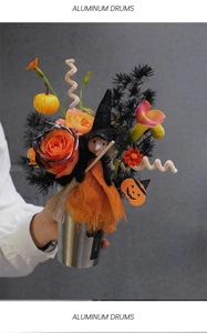 Detail of Halloween floral decor with orange roses and witch doll in aluminum cup