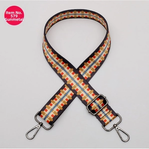Detail of adjustable polyester bag strap with geometric patterns and gunmetal hardware
