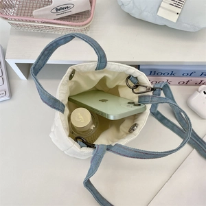 Vue de dessus de l'intérieur d'un sac seau matelassé blanc avec anses en denim bleu
