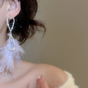 Elegante goldene Ohrhänger mit glänzenden Strasssteinen und lila Federn für Damen