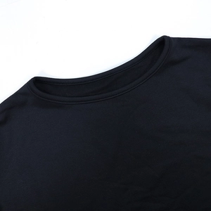 Gros plan sur l'encolure ronde et la texture en coton doux de ce haut noir à manches longues