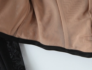 Gros plan sur la dentelle noire sur mesh chair avec finitions en satin noir
