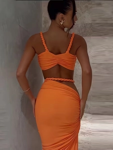 Orange two-piece set featuring a halter crop top and slit maxi skirt in pleated fabric
