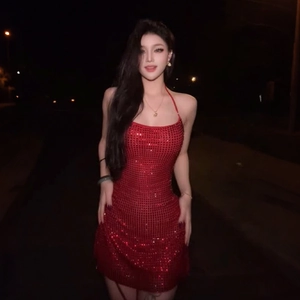 Gros plan sur une robe dos nu rouge à paillettes avec une coupe moulante sexy