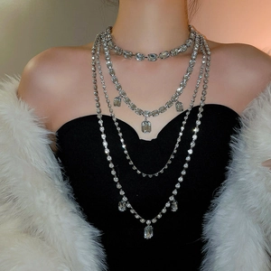 Close-up of silver layered tassel necklace with crystal pavé and rectangular pendants
