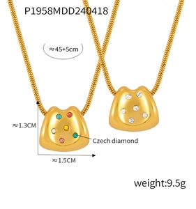 Macro del ciondolo a forma di gatto portafortuna con diamanti cechi colorati e catena oro
