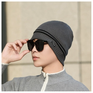 Close-up of a dark grey knitted beanie with double stripes and side woven label