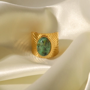 Vintage gold open ring featuring a large oval green turquoise stone on silk fabric