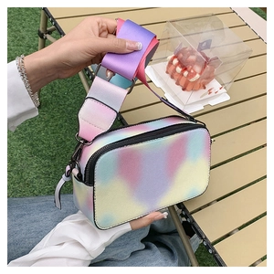Close-up of rainbow gradient camera bag with a wide colorful fabric shoulder strap