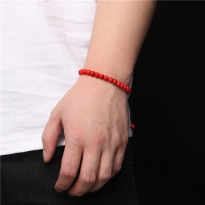 Detail shot of a 6mm red tiger eye stone bead bracelet with handmade woven knot on wrist