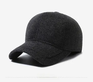 Detail of dark grey herringbone wool texture and sports metal tag on winter baseball cap