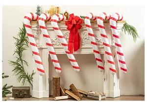 Set of six red and white striped inflatable candy canes hanging on a festive fireplace