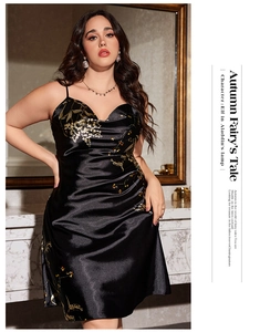 Detail of plus size black silk satin camisole dress featuring golden floral print