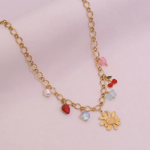 Détail d'un collier doré avec pendentifs fraise, marguerite, papillon et perle
