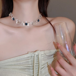 Close-up of heart beaded necklace with blue crystal accents on a model neck