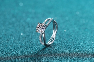 Macro detail of cross-band sterling silver ring with 1ct moissanite and pave setting