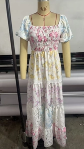 Détail d'une robe fleurie à manches bouffantes avec bustier élastique et bordure dentelle
