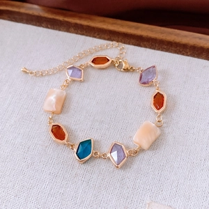 Detailed close-up of a vintage style gold chain bracelet with colorful geometric stones