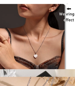 Nahaufnahme einer luxuriösen Herz-Muschel-Halskette an einem Model mit Goldschmuck