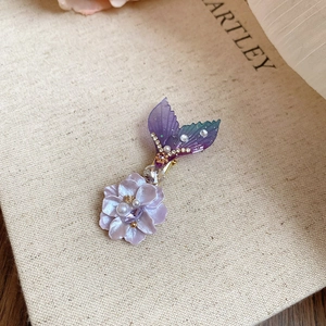 Détail de la pince à cheveux avec cristaux violets, perles et motif queue de sirène