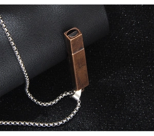 Close-up of vintage bronze whistle pendant on chain with antique finish detailing