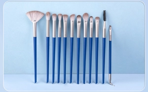 Detail of 12pcs royal blue makeup brush set with synthetic bristles on light blue background
