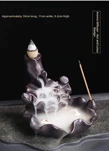 Macro detail of ceramic lotus leaf incense burner with red koi fish and flowing smoke