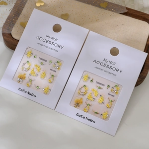 Detailed view of 3D embossed floral nail charms with yellow flowers and rhinestones