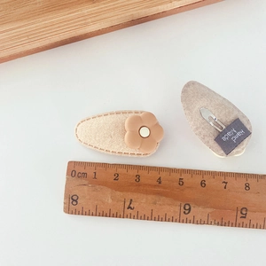 Detail of 5.5cm handmade milk tea flower hair clip with metal duckbill clip and soft felt texture