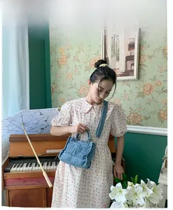 Mini vintage blue denim crossbody bag with utility pockets in a French retro setting
