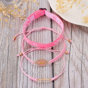 Close-up of pink LOVE ribbon bracelet and Saint Mary pendant with sparkling rhinestones