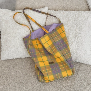 Detail of canvas tote bag with yellow and purple checkered pattern and light purple lining