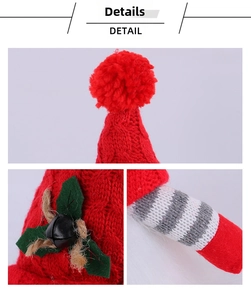 Close-up of red knit Christmas gnome hat featuring holly leaf and black bell decorations