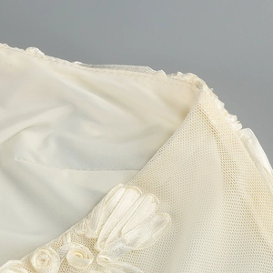 Macro detail of 3D rosette flower on mesh and silk halter dress fabric