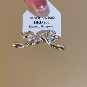 Détail des boucles d'oreilles nœuds torsadés en argent sterling 925 sur carte