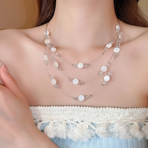 Détail du collier multicouche avec coquillages et perles de cristal porté sur le cou