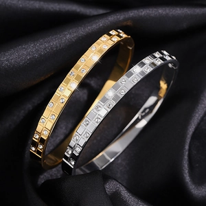 Detailed close-up of gold and silver titanium waffle bangles with inlaid diamonds