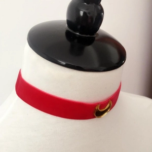 Red velvet choker with golden crescent moon pendant on a white mannequin bust