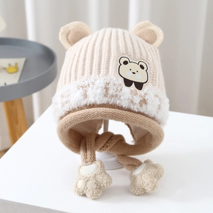 Detail showing the beige cable knit earflap hat with cute bear ears and plush trim