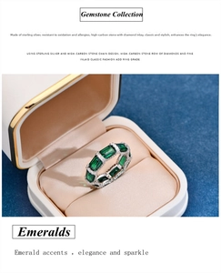Macro shot of emerald cut green stones set in sterling silver ring inside a jewelry box