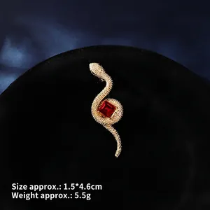 Detailed macro view of snake brooch with ruby and gold metal finish, size 1.5x4.6cm