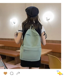Model wearing a light green large-capacity casual backpack in a cozy cafe setting
