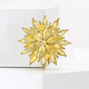 Detail view of snowflake brooch with yellow marquise-cut zircons on a gold-plated base