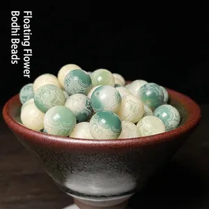 Macro shot of floating flower bodhi beads with wave carvings in a black ceramic bowl