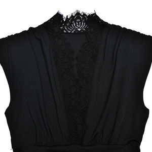 Dettaglio di un elegante body nero con patchwork in pizzo a V e texture di tessuto a pieghe